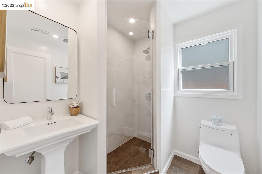 Secondary full bathroom with brown tile and white walls